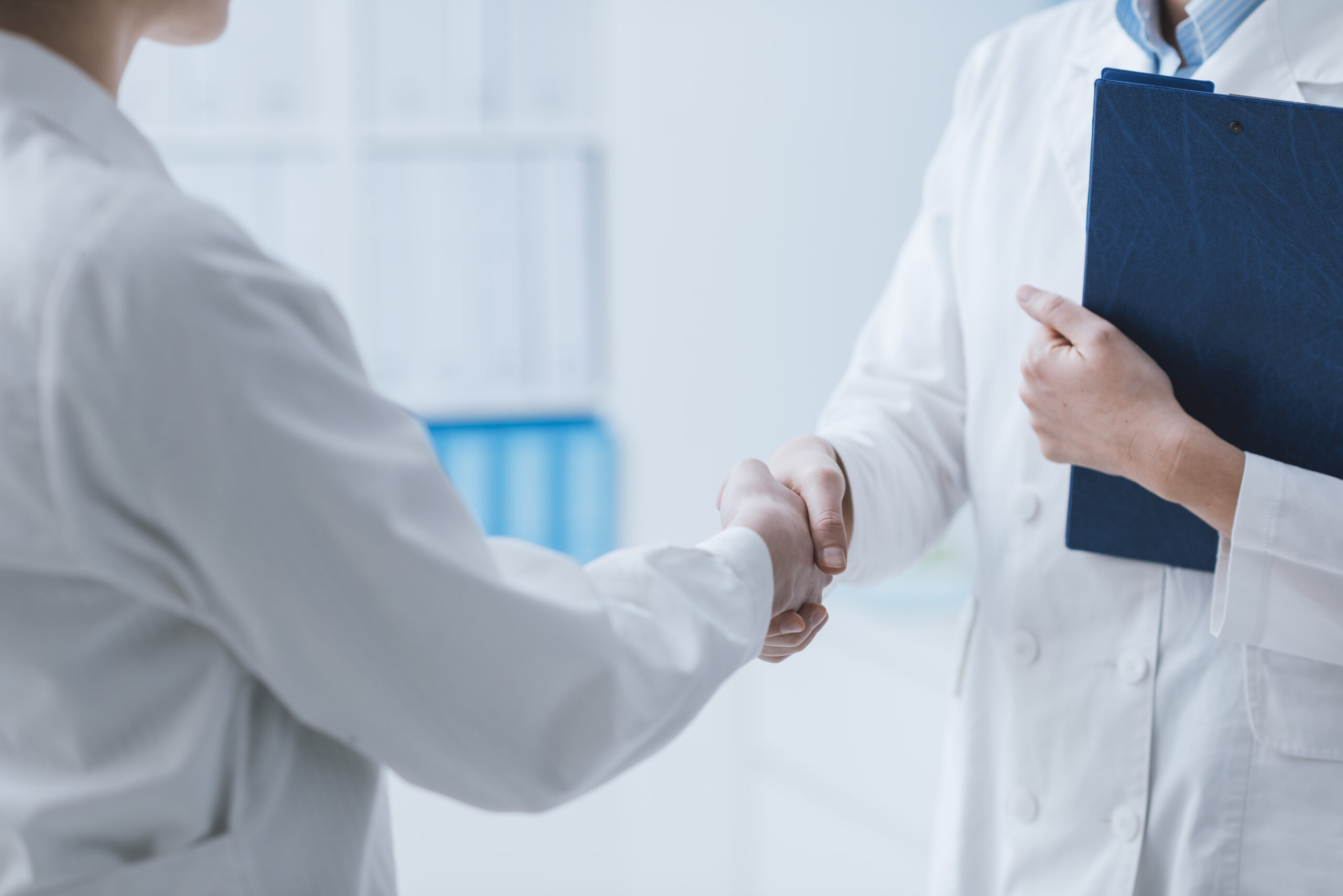 a doctor and marketing professional shaking hands after discussing the phmc guidelines