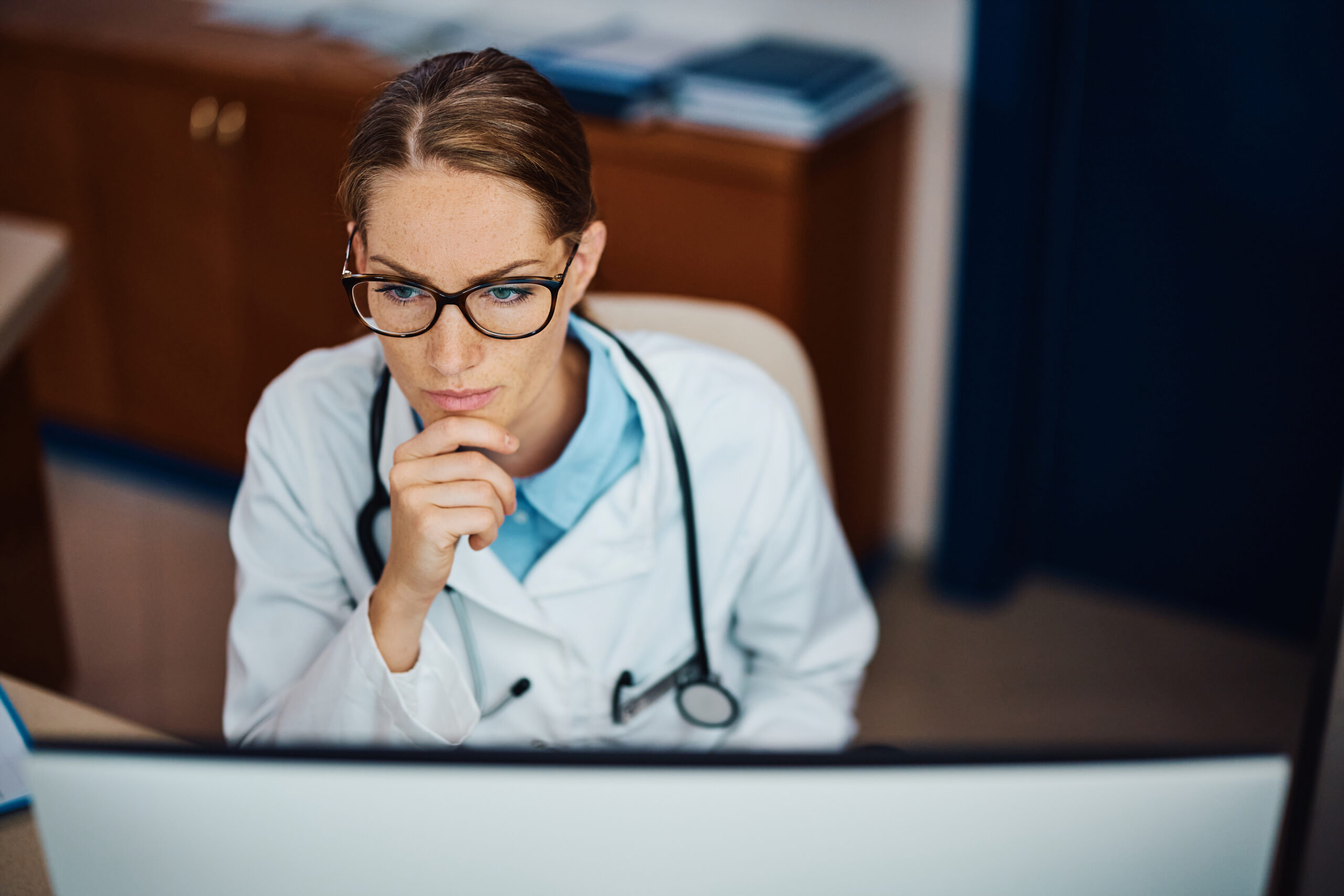 a female doctor reviewing the phmc guidelines in a computer in her office